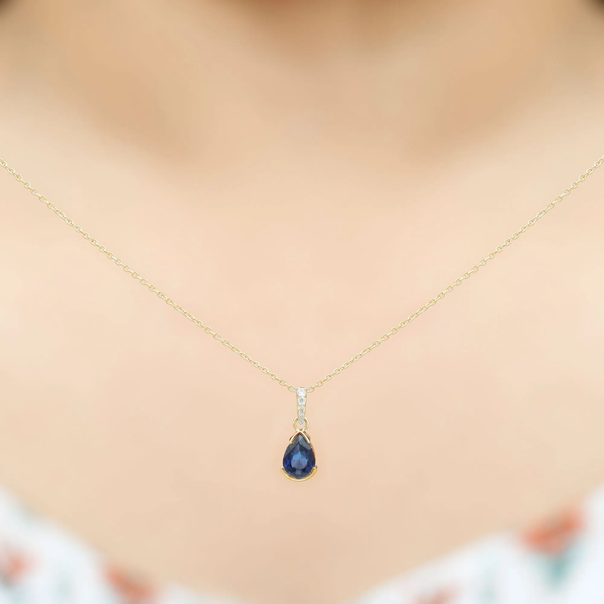 1 CT Pear Cut Blue Sapphire Solitaire Pendant in Half Bezel Setting with Diamond Accent Bail