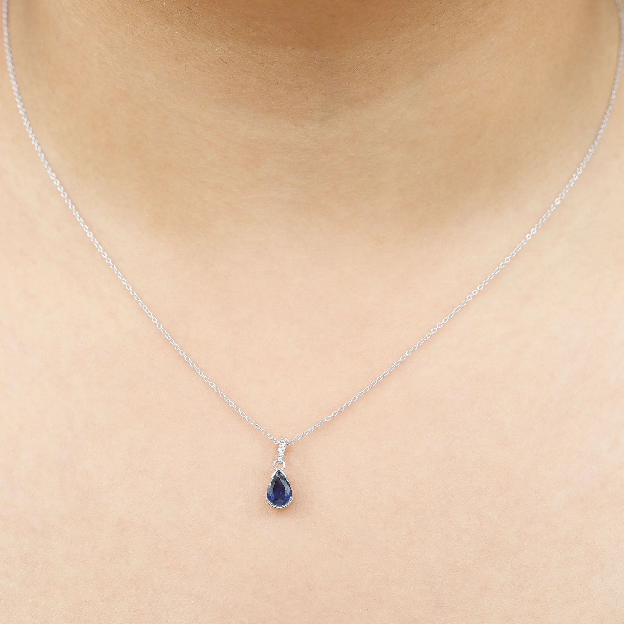 1 CT Pear Cut Blue Sapphire Solitaire Pendant in Half Bezel Setting with Diamond Accent Bail