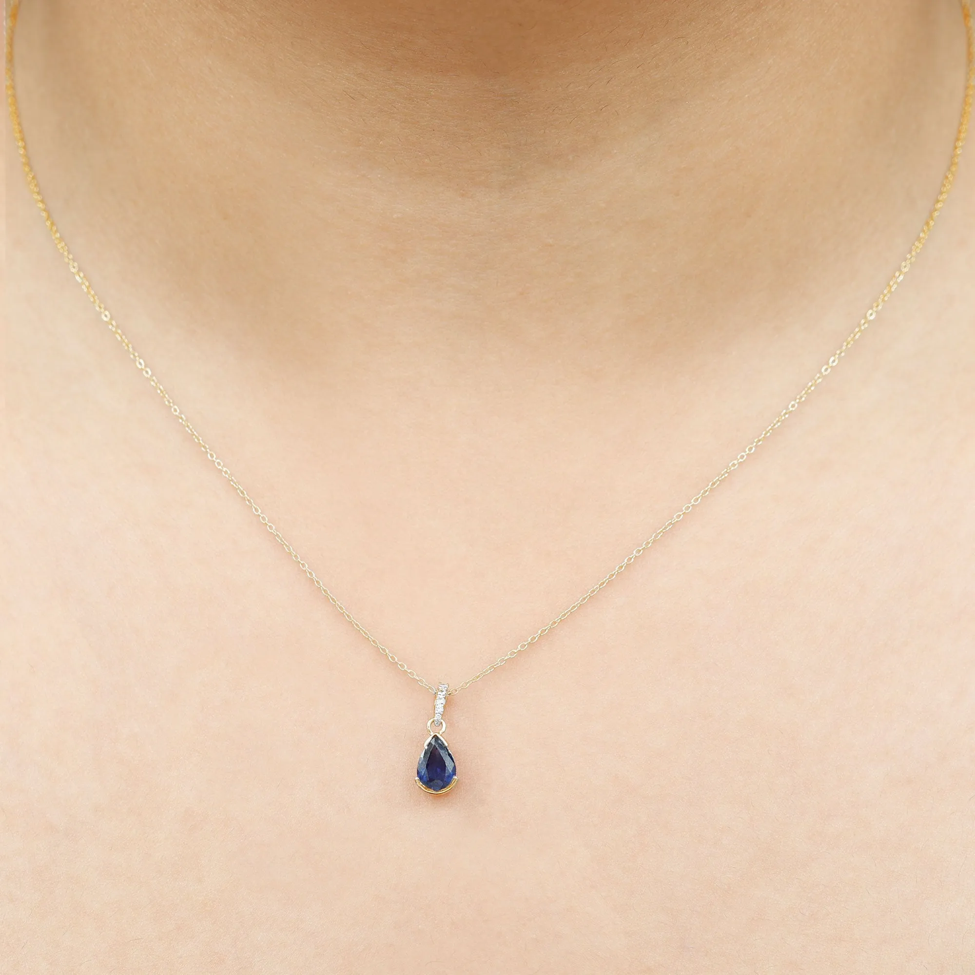 1 CT Pear Cut Blue Sapphire Solitaire Pendant in Half Bezel Setting with Diamond Accent Bail